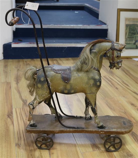 A Victorian painted and decorated carved wood push along horse